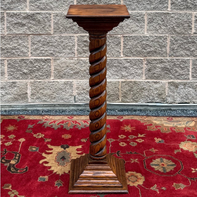 A vintage Jacobean Revival plant stand or pedestal having a square crown molding top and base with barley twist column...