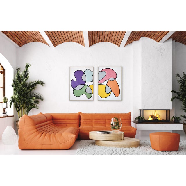 This abstract diptych features flowing, organic forms layered in a playful palette. The composition balances movement and...