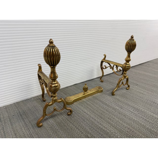 Design Plus Gallery presents a Set of Three Brass Fireplace Andirons + Front Rail. This vintage three-piece set includes a...