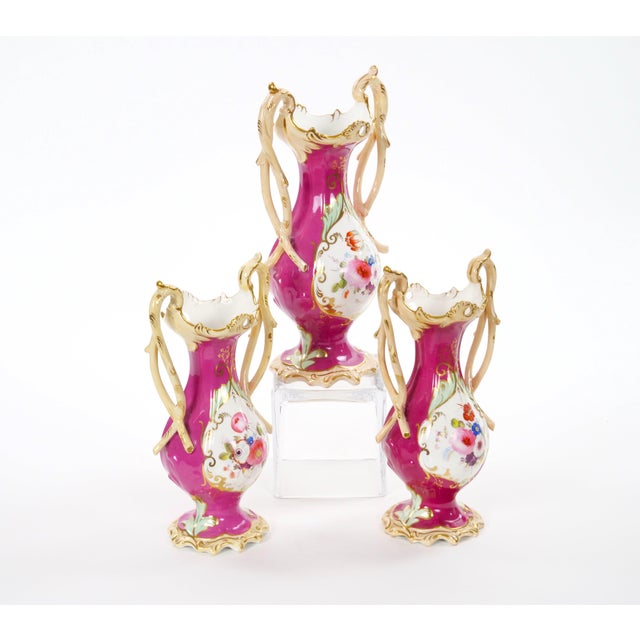 This elegant three-piece Antique English porcelain garniture set was made in England in the 19th century and consists of a...