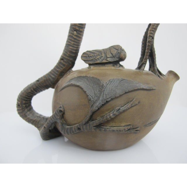 Handmade Chinese Yixing Zisha clay teapot, uniquely sculpted to resemble gnarled textured tree branches, mimicking a peach...