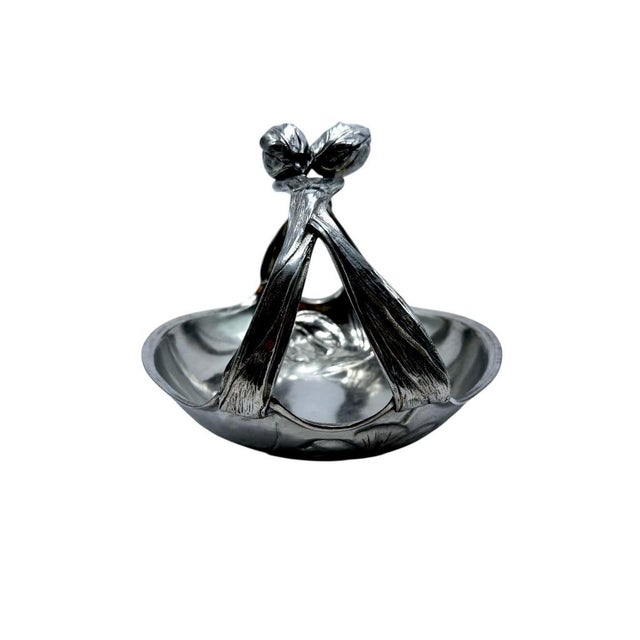 Elegant early 20th centry pewter basket with tulip-inspired accents, showcasing intricate floral designs and a decorative,...