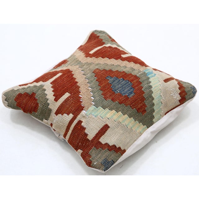 A one-of-a-kind handwoven Afghan wool kilim accent pillow featuring large hooked diamond in red and cream with blue...