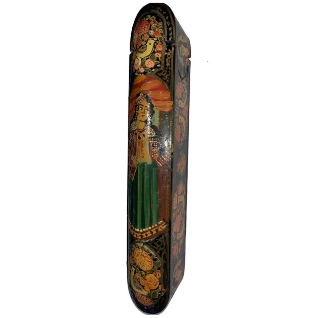 A polychrome lacquer papier mache pen case. Qajar Iran 20th century. With rounded ends and sliding tray, decorated all...
