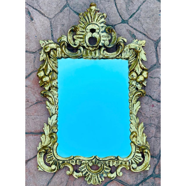 This decorative wall mirror is crafted in molded plaster and finished with a gilt surface, designed in the Baroque style....