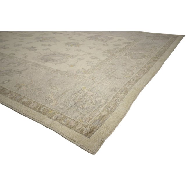 This hand knotted wool Turkish Oushak rug features a graceful features an all-over botanical pattern composed of Harshang-...
