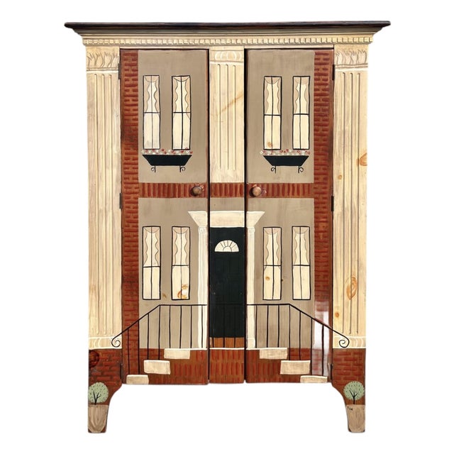 A charming trompe l'oeil cabinet painted to resemble a townhouse facade, complete with white carved columns, an arched...