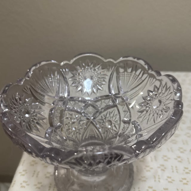This elegant vintage vase features a striking starburst design pressed into its solid glass base, catching the light...