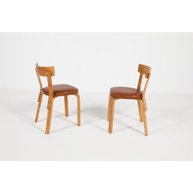 Early edition pair of chairs from Alvar Aalto, produced in 1930’s. Lacquered birch frame with new seat upholstery in...