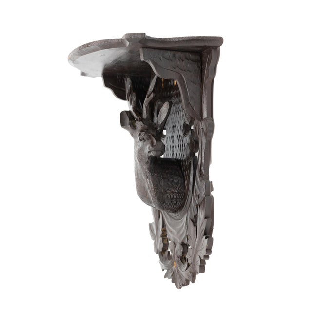 Black forest carved wall shelf in Lindenwood, with a central carved stag on a shaped plaque with carved oak leaves and...