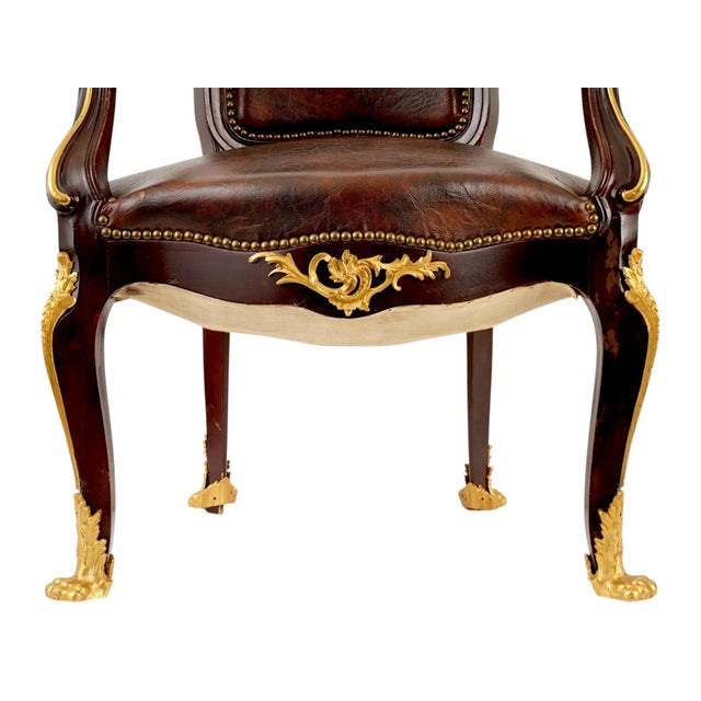A French armchair is executed in the opulent style of Francois Linke, featuring a shaped backrest and seat upholstered in...