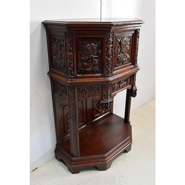 Solid walnut cabinet, generously carved, in the spirit of Gothic religious art Its pentagonal facade features, in the...