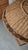 Round woven basket featuring a coiled grass or fiber design with decorative rim accented by coconut shell disc. 16"...