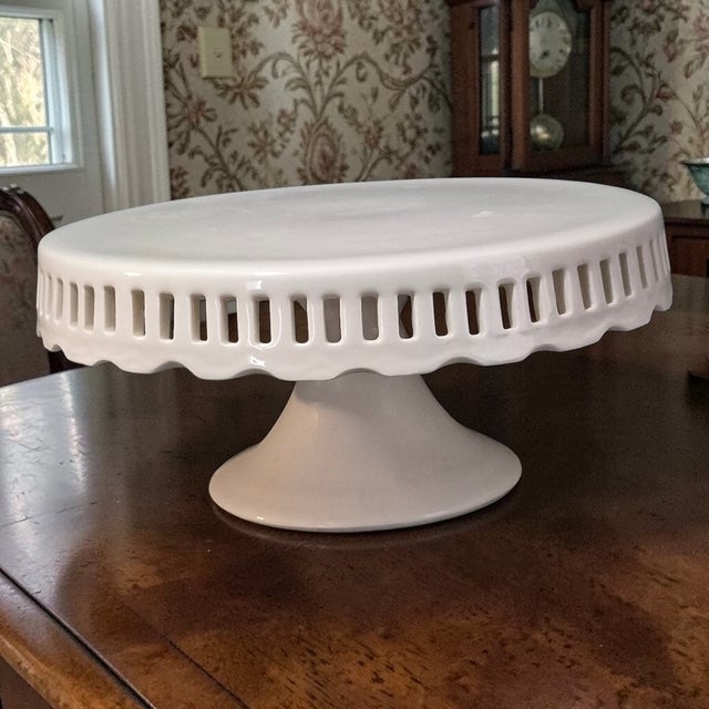 The "Crace's Teaware" White Porcelain Pedestal Cake Stand is a stylish and elegant addition to any dining table or special...