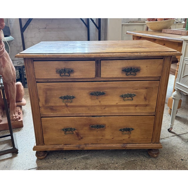 Antique pine dresser, circa 1900, with a classic 2-over-2 drawer layout and dovetailed construction. Features bun feet at...