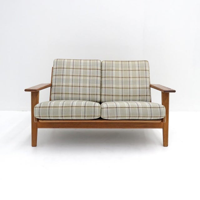 wonderful Danish two-seat sofa, model GE290/2 designed by Hans J. Wegner for GETAMA, 1950, with a solid oak frame and...