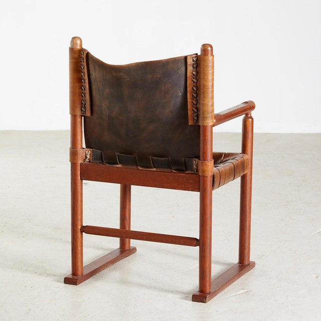 Dark oak framed lounge chair with genuine leather seat and backrest.