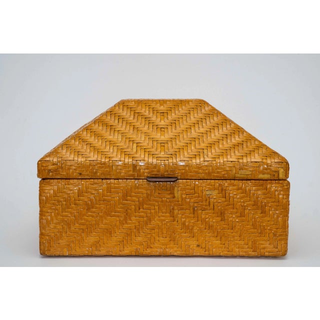 This vintage huge box is woven cross cross rattan style leather over wood and a wood interior. It is from the 70's or...