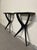 A pair of 1950s Italian-made console tables, also sold separately. The "X"-shaped structure is made of ebonized wood and...