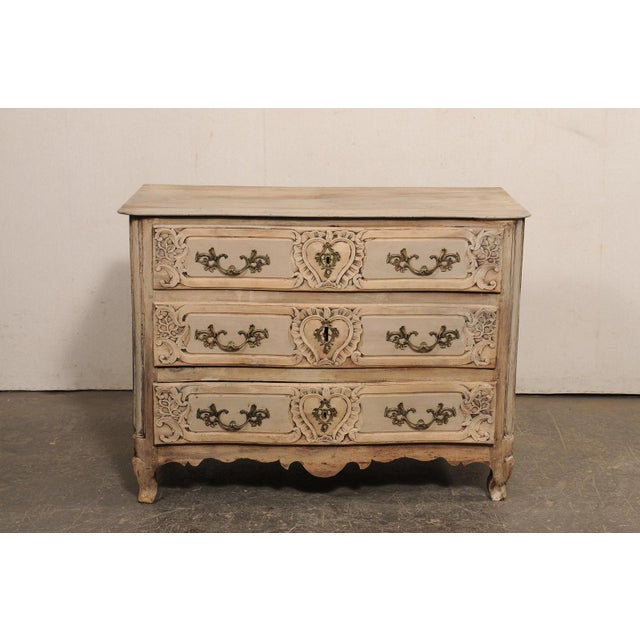 A French Louis XV serpentine commode, with elaborately carved drawer fronts, from the 18th century. This antique chest...