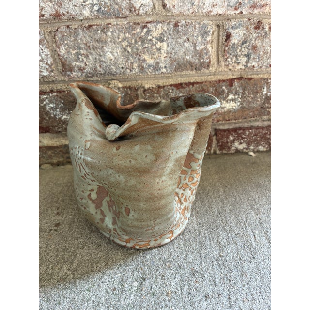 Vintage ceramic studio vessel, featuring a textured, speckled white and brown reactive glaze on a pale blue / green base....