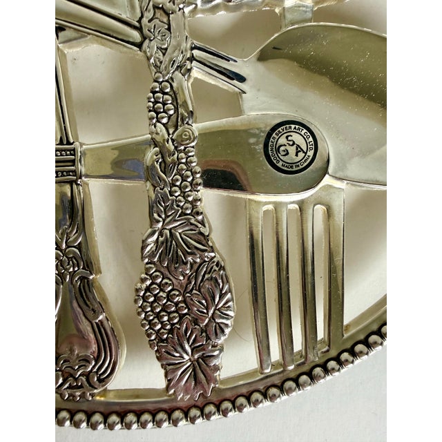 This charming, vintage silver-plated trivet was made by Godinger Silver Art Co. during the late 20th century and features...