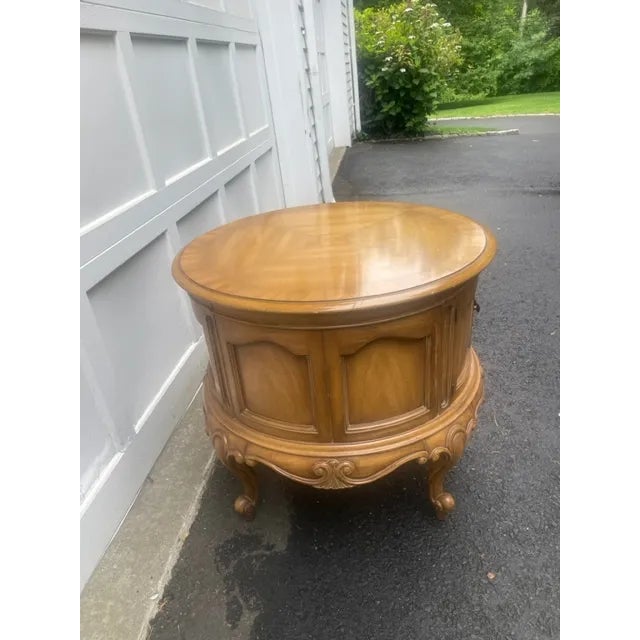 Heirloom quality table featuring round top above a single door . Doors open to reveal compartment storage over a scalloped...