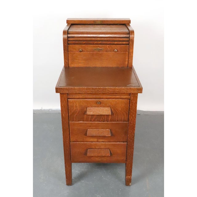 This oak cabinet was designed for businesses to manage financial records and registers. The distinctive upper section...
