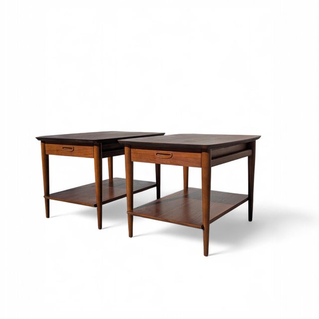 This pair of end tables by Lane Furniture exemplifies the streamlined functionalism of American Mid-Century Modern design....
