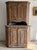 A tall 18th-century Swedish cupboard in dry scraped paint, the blue and ochre worn back to bare wood across the canted...