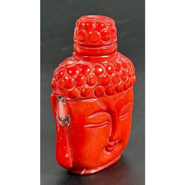 This is an exceptional snuff bottle masterfully carved from a single block of genuine red coral. It features a serene...