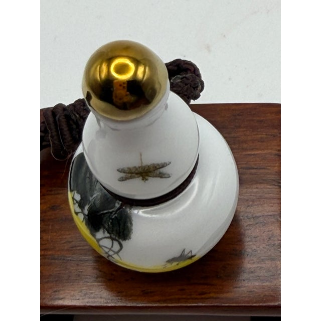 This is a very small painted porcelain snuff bottle with a string necklace attached so the bottle can be worn as a...