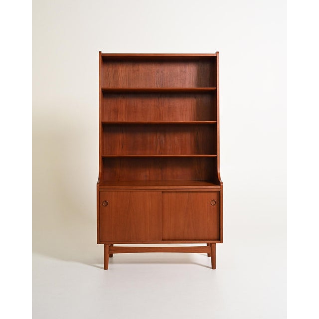 Teak structure with four adjustable shelves at the top and a lower compartment closed by two sliding doors with an...