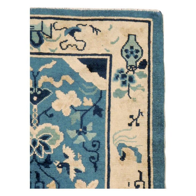 A vintage Chinese Peking throw rug handmade during the mid-20th century with a cream border and light blue field....