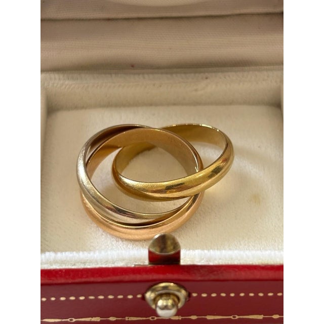 A beautiful cartier trinity ring in three golds, weighing 11.8 grams. Signed inside 750 cartier 56 (corresponding to the...