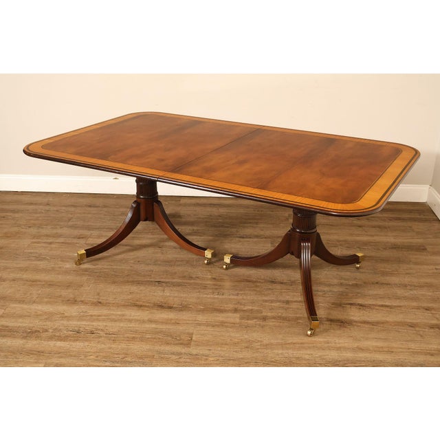 High Quality American Made Banded Mahogany Expandable Dining Table on Reeded Pedestals with Brass Feet and Rolling...