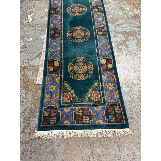 Design Plus Gallery presents a 2ft 6in × 9ft 10 in Tibetan Teal Runner Rug. This Tibetan runner rug showcases a teal field...