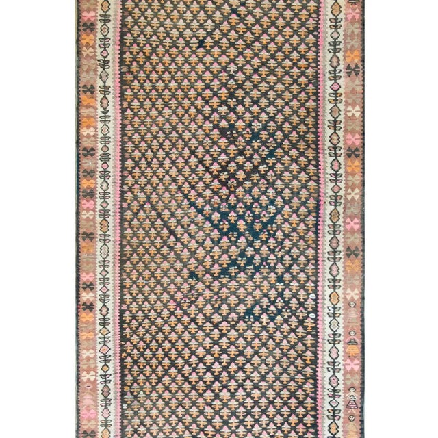 An incredible early 20th century Kurdish Kilim rug with an all-over stylized tree-of-life pattern woven in pink, orange,...