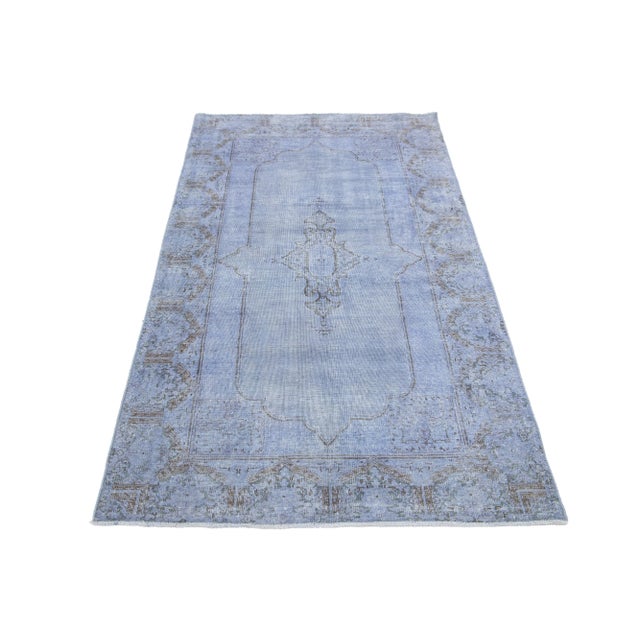 This vintage overdyed Persian wool rug features a captivating light blue color field with charming brown floral accents....