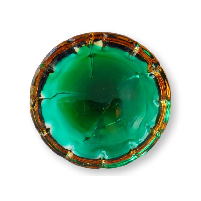 Featuring a stunning blend of emerald green and amber hues, this Midcentury Murano Triple Sommerso Geode Ashtray...