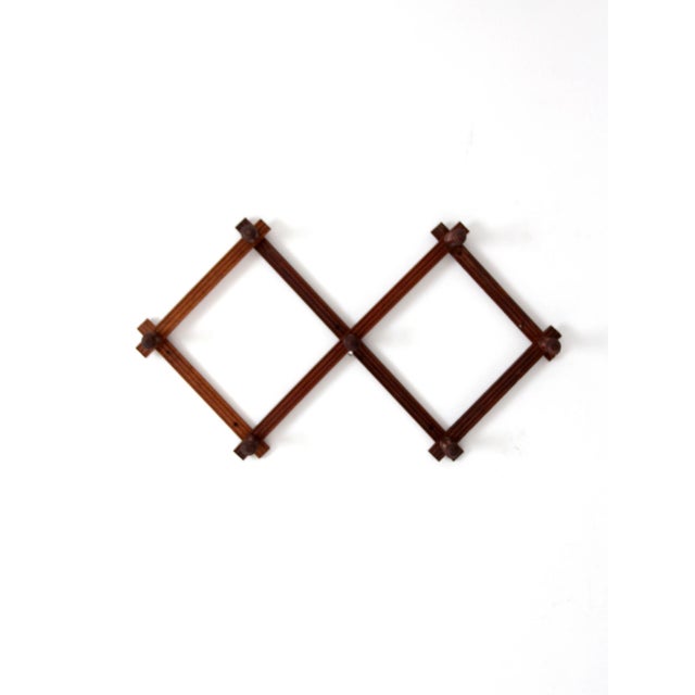 Vintage expanding accordion wall rack with turned wooden pegs and a warm stained finish. Adjustable design extends and...