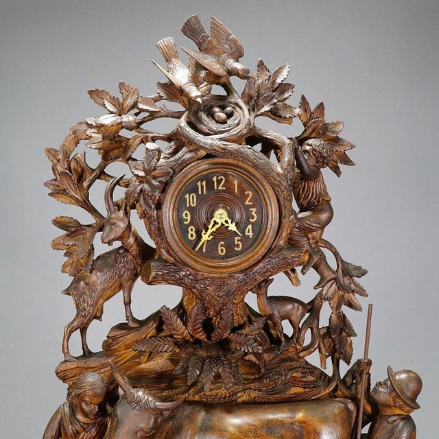A Black Forest wooden carved mantel (fireplace) clock with a lovely herdsman family with their goats and cows. a...