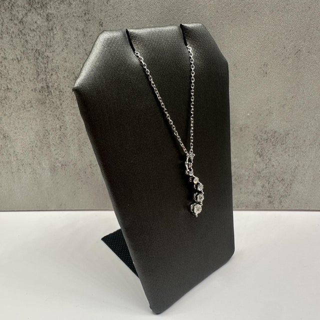 This elegant diamond journey necklace in 10kt white gold features 0.25 carats total weight of natural GH SI round diamonds...