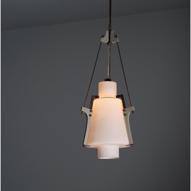 Italian pendant lamp from the 1950s, distinguished by a refined and sophisticated mid-century modern design. The lamp...
