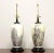A pair of Asian style table lamps, unbranded. Made of porcelain in an urn style with a creamy white background, silver and...