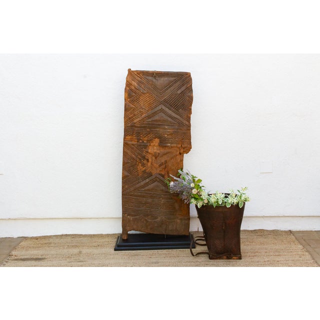 Hand-carved from a single length of hardwood, this door carries Mali's Dogon or Bamana geometric tradition in a dense...