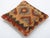 A one-of-a-kind handwoven Afghan wool kilim accent pillow featuring concentric ikat diamond in warm tones. Cut and sewn by...