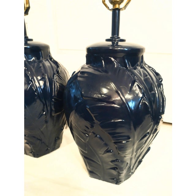 A pair of beautiful vintage plaster palm leaf designed table lamps freshly painted in a dark glossy navy blue color. The...