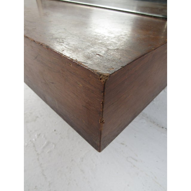 This stunning vintage modern mirror features an unusual textured trim resembling mother of pearl around the edges. The...