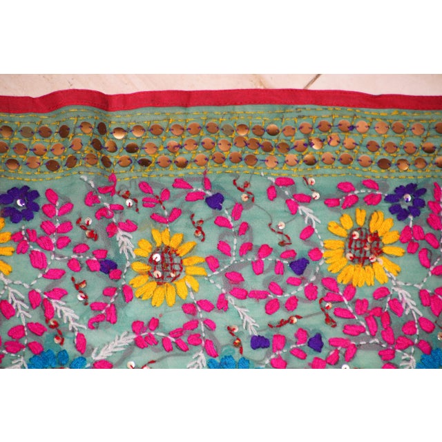 Vintage Suzani Embroidery in teal background with yellow, pink turquoise and adorned with sequins. "Suzani" means...